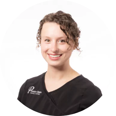 Smiling female dental team member with curly hair wearing a Premier Choice Dental Center uniform.