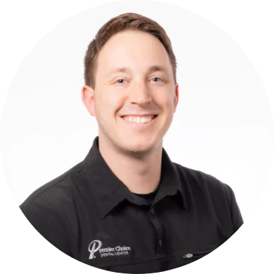 Smiling male dental staff member at Premier Choice Dental Center in a black uniform.